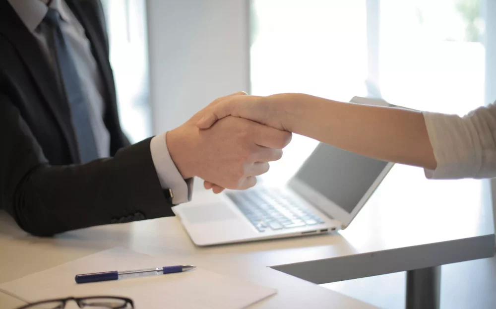 Deux personne se serrent la main lors d'un entretien d'embauche